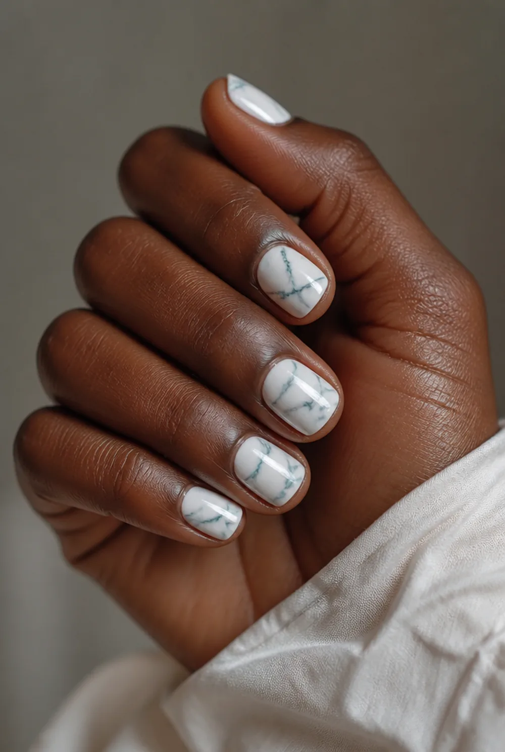 teal marble nail art on deep brown skin