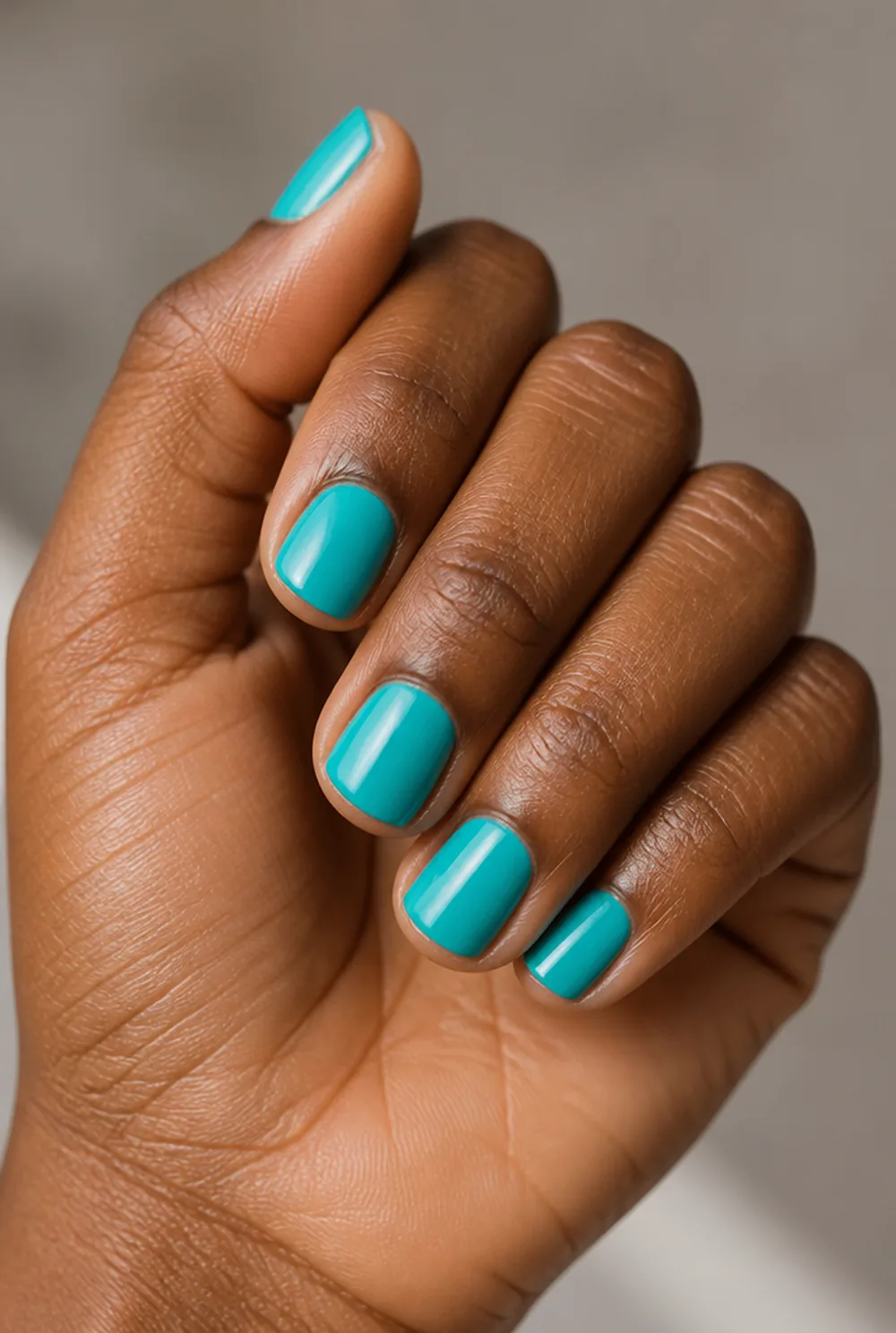 turquoise nail art on deep brown skin