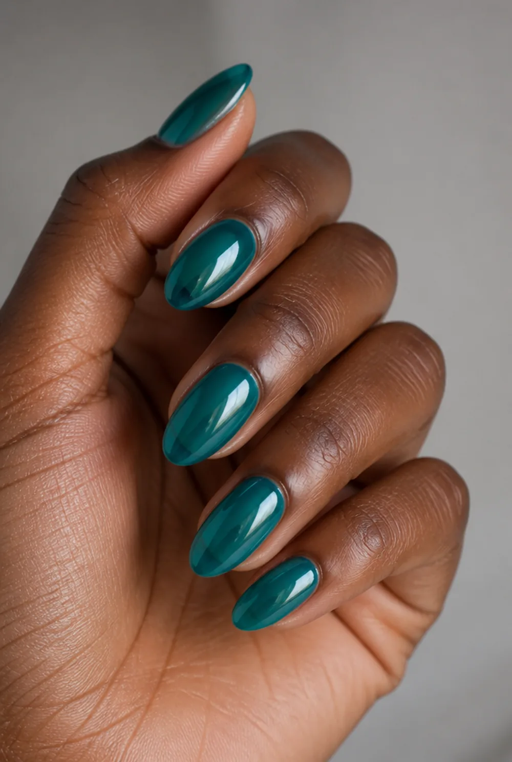 long teal almond nail art on deep brown skin