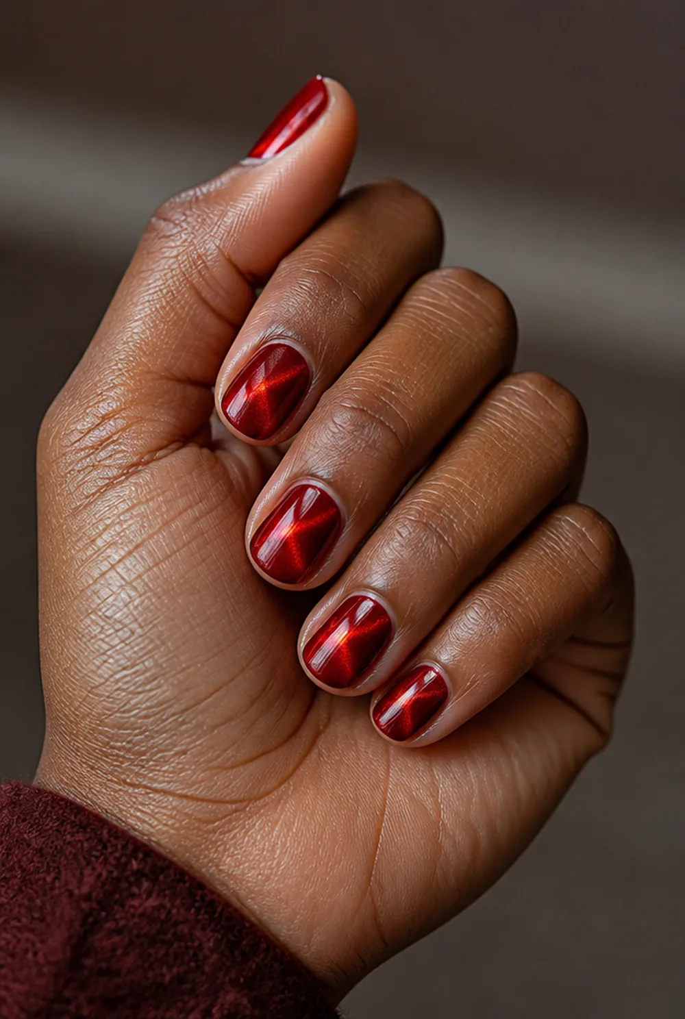 red cat eye nail art on deep brown skin