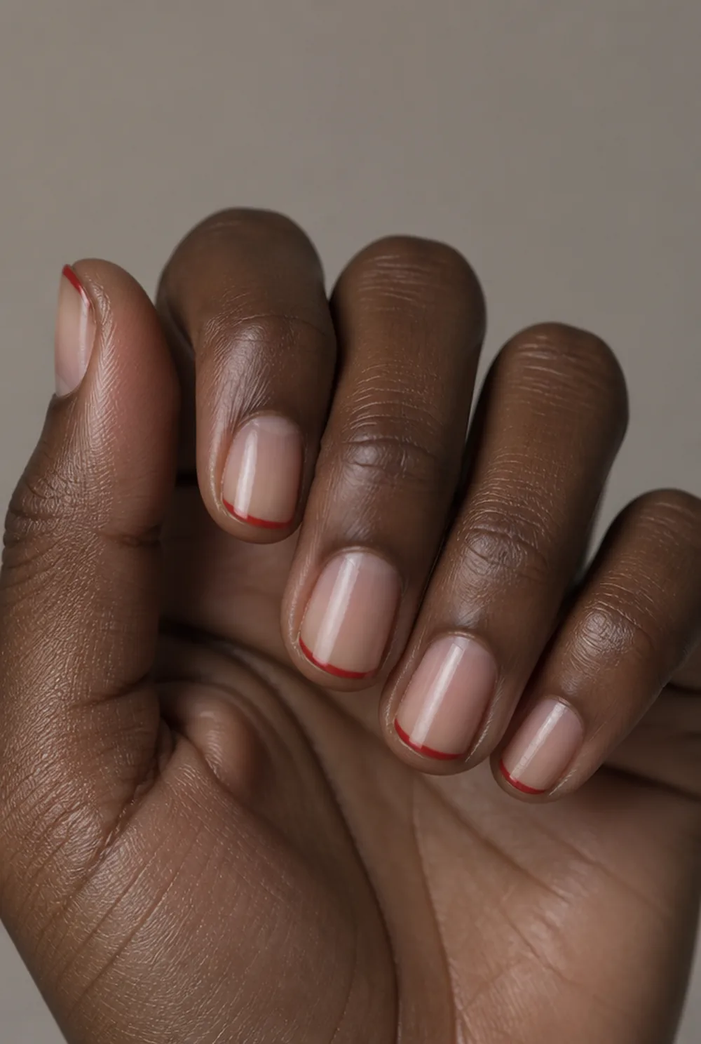 red micro french nail art on deep brown skin