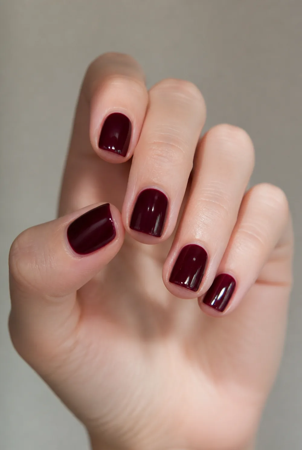 burgundy nail art on fair skin, short length