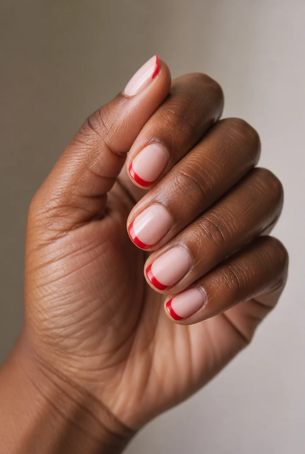 pink base, red tips nail art on deep brown skin