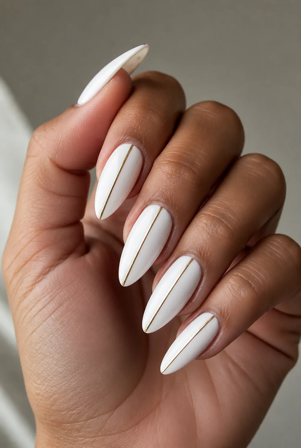 white with gold line nail art on olive skin, long length