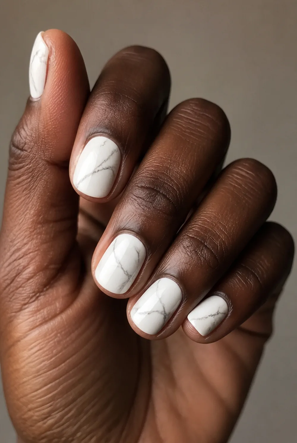 white marble nail art on deep brown skin