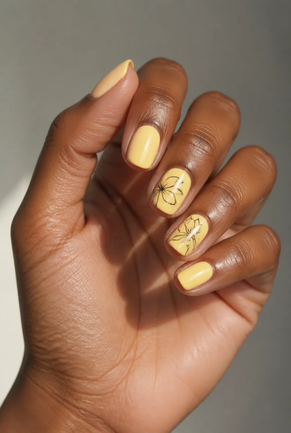 yellow with black line art nail art on deep brown skin