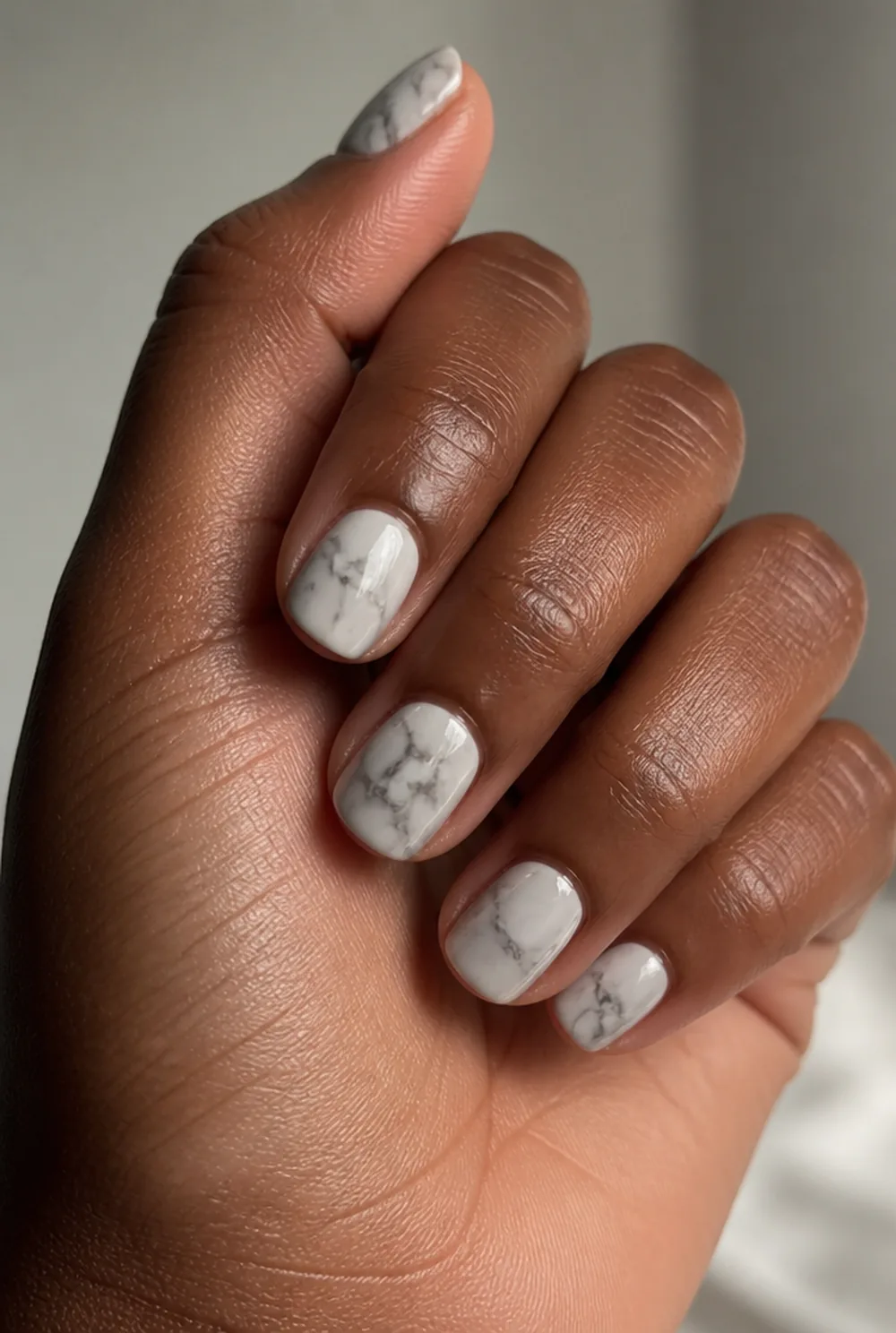 abstract marble nail art on deep brown skin
