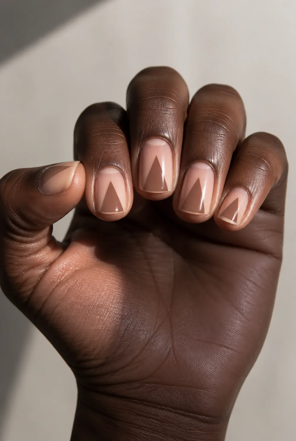 negative space triangle nail art on deep brown skin