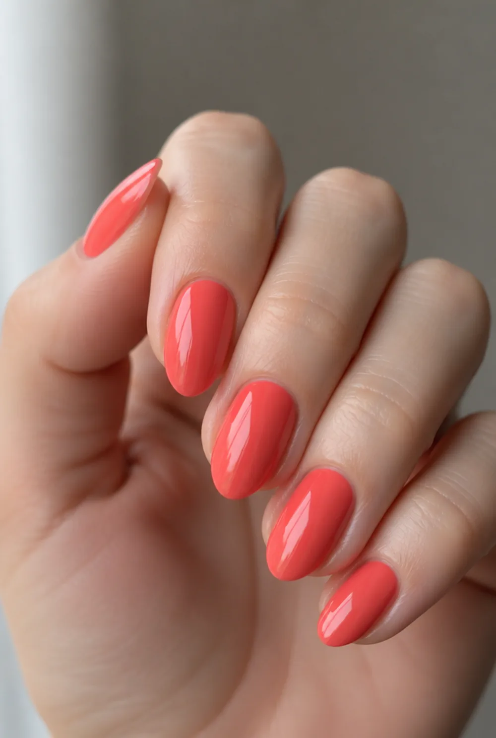 classic coral creme nail art on fair skin, short length