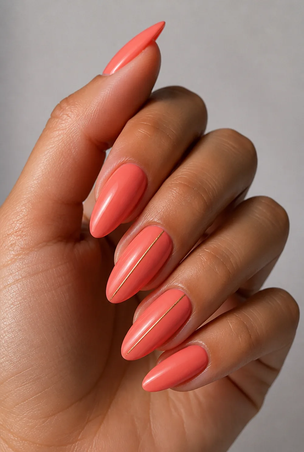 coral and gold nail art on olive skin, long length