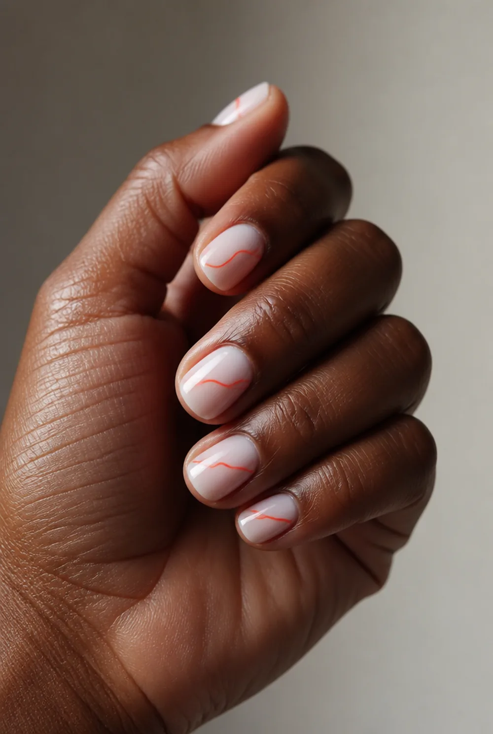 coral swirl nail art on deep brown skin