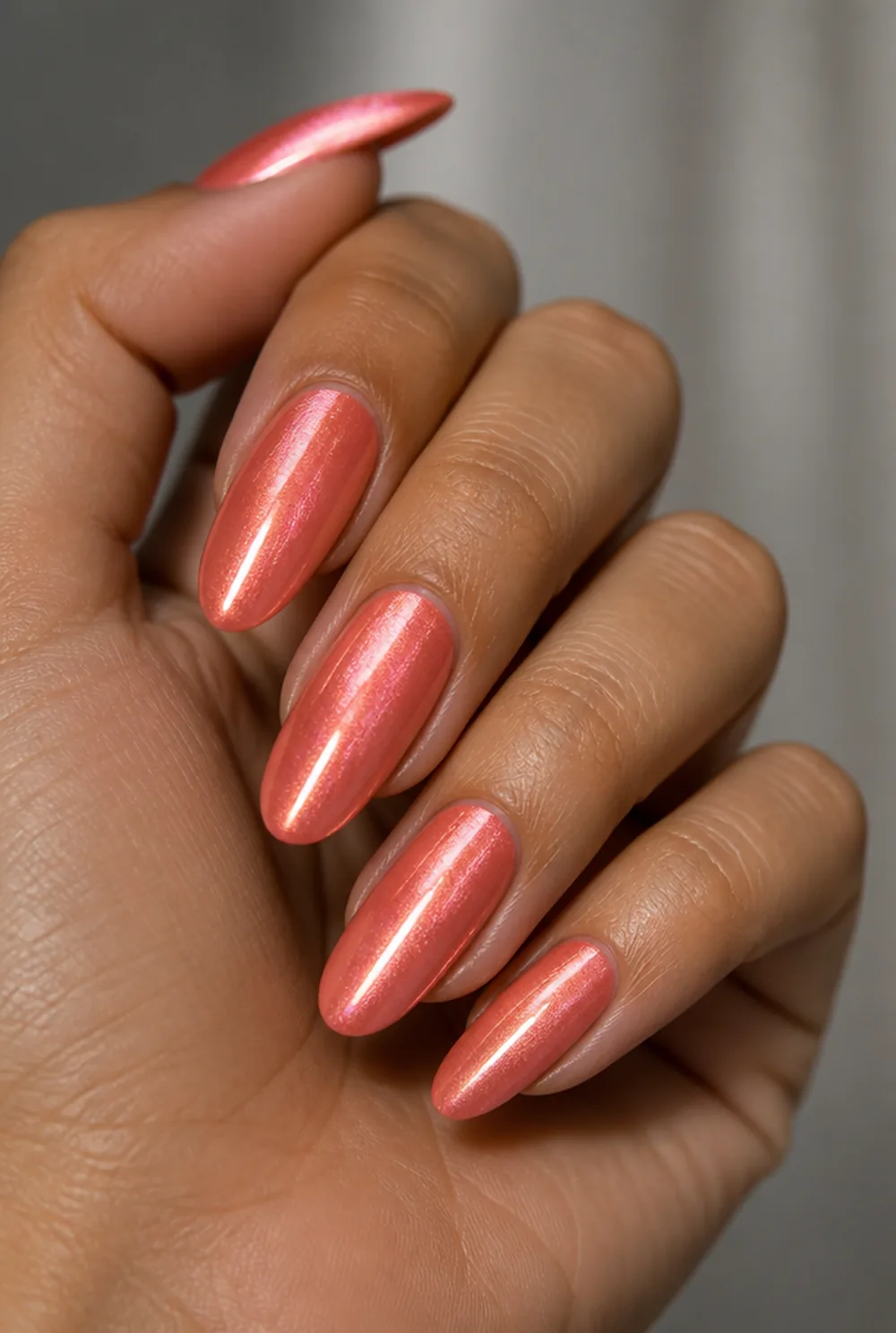 coral cat eye nail art on olive skin, long length