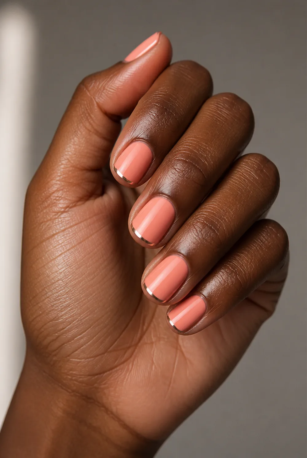 coral with chrome tips nail art on deep brown skin