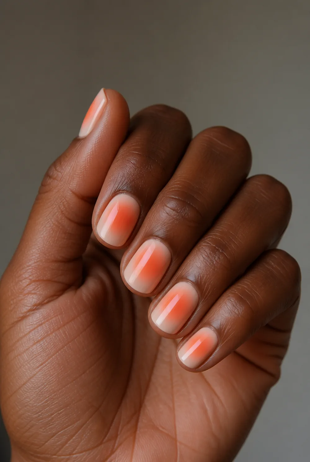 coral aura nail art on deep brown skin