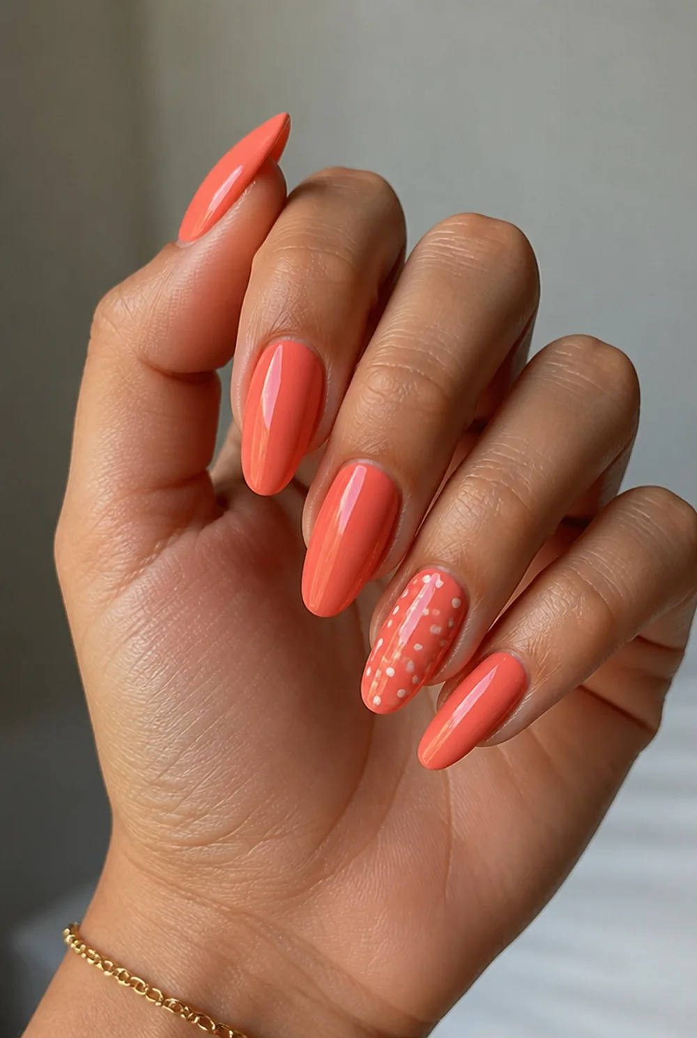 coral with white dots nail art on olive skin, long length