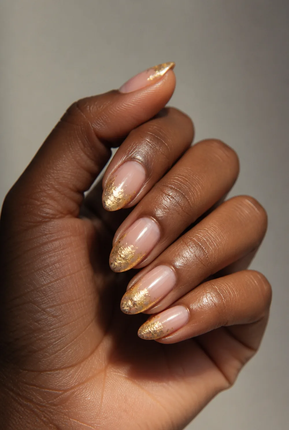 foil tips on almond nail art on deep brown skin