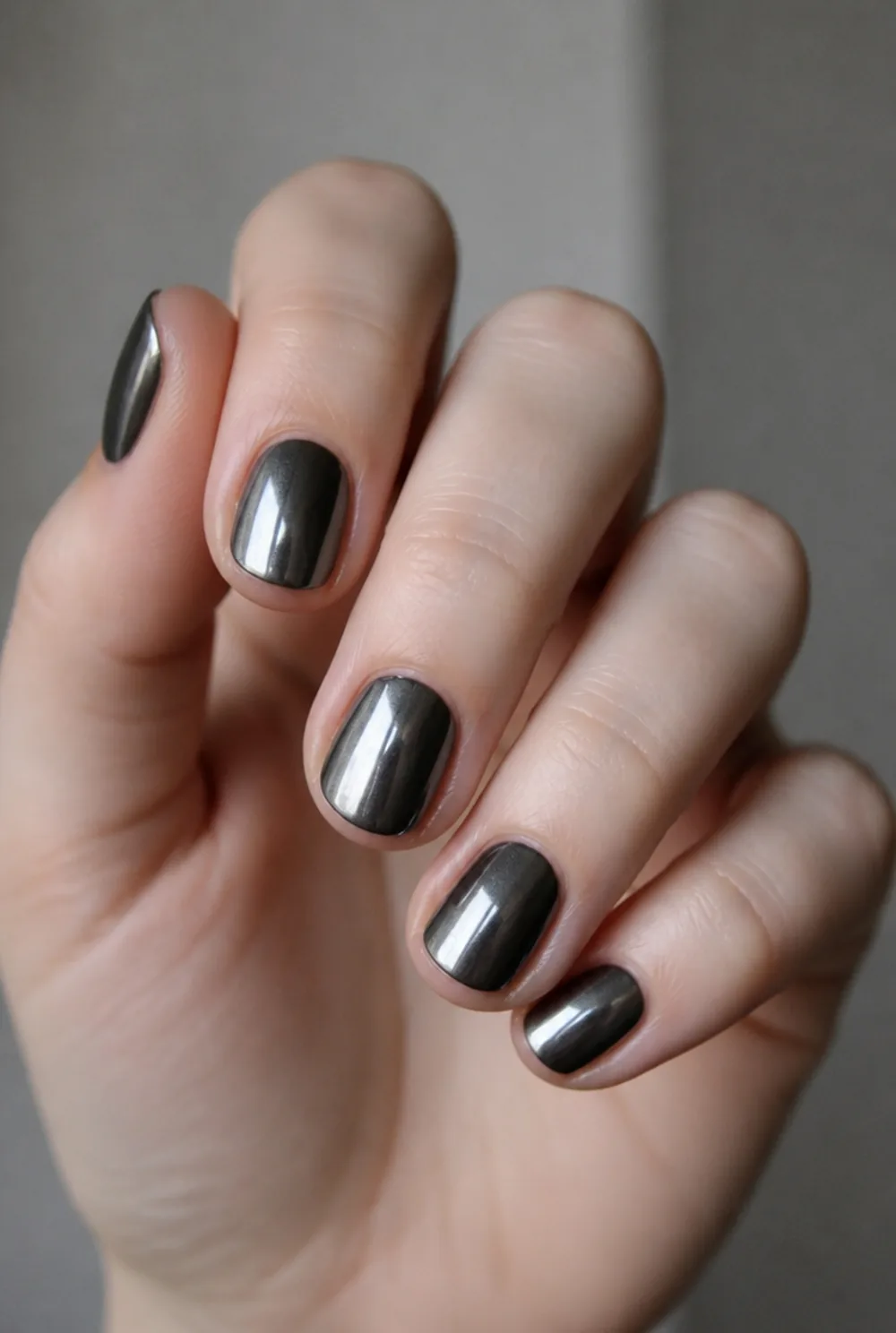grey chrome nail art on fair skin, short length