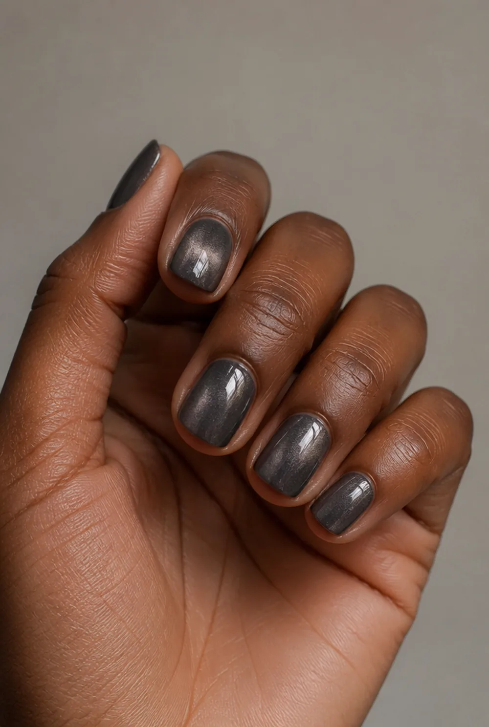 grey cat eye nail art on deep brown skin