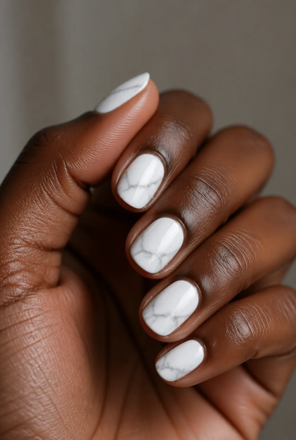 grey marble nail art on deep brown skin