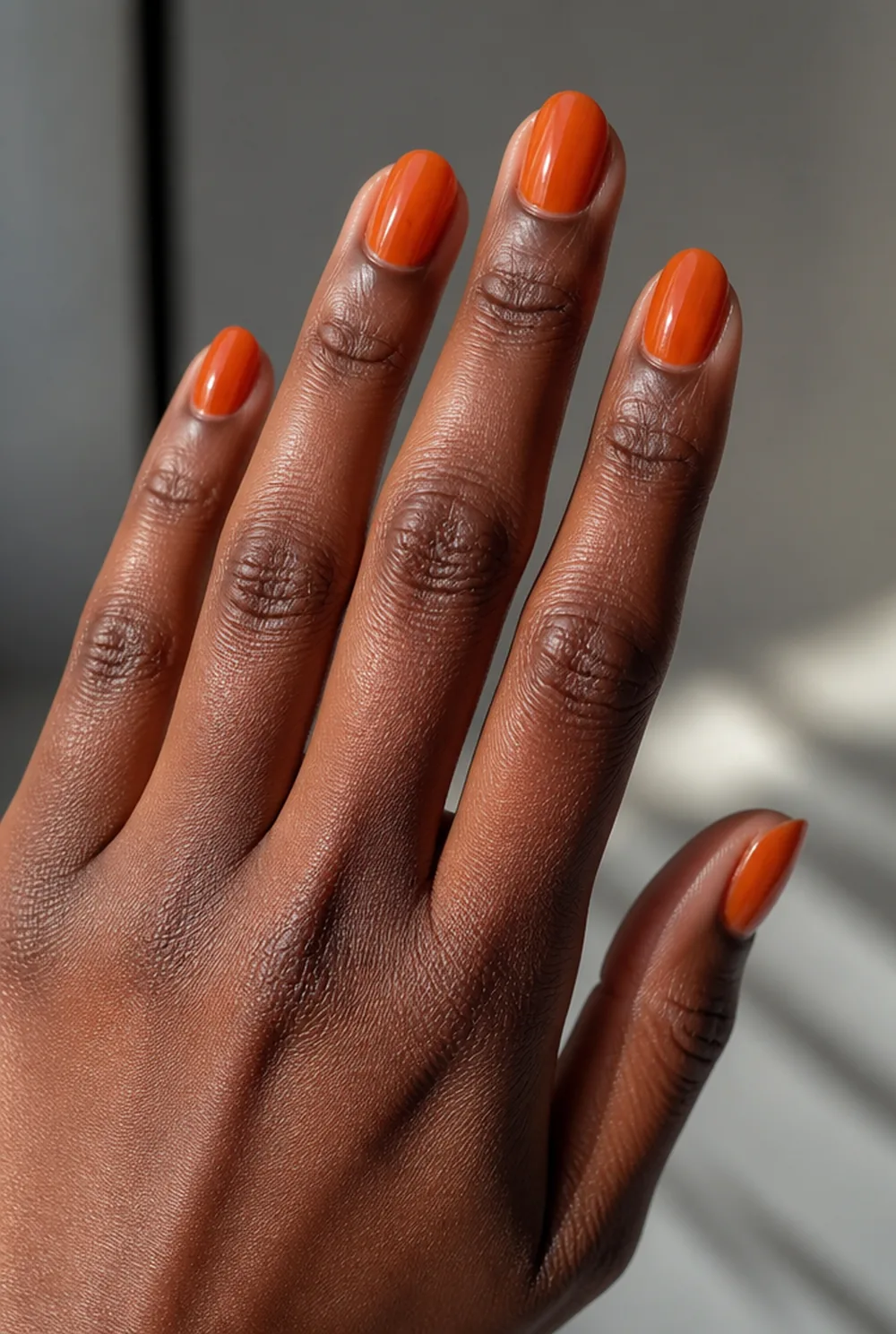 jelly orange nail art on deep brown skin