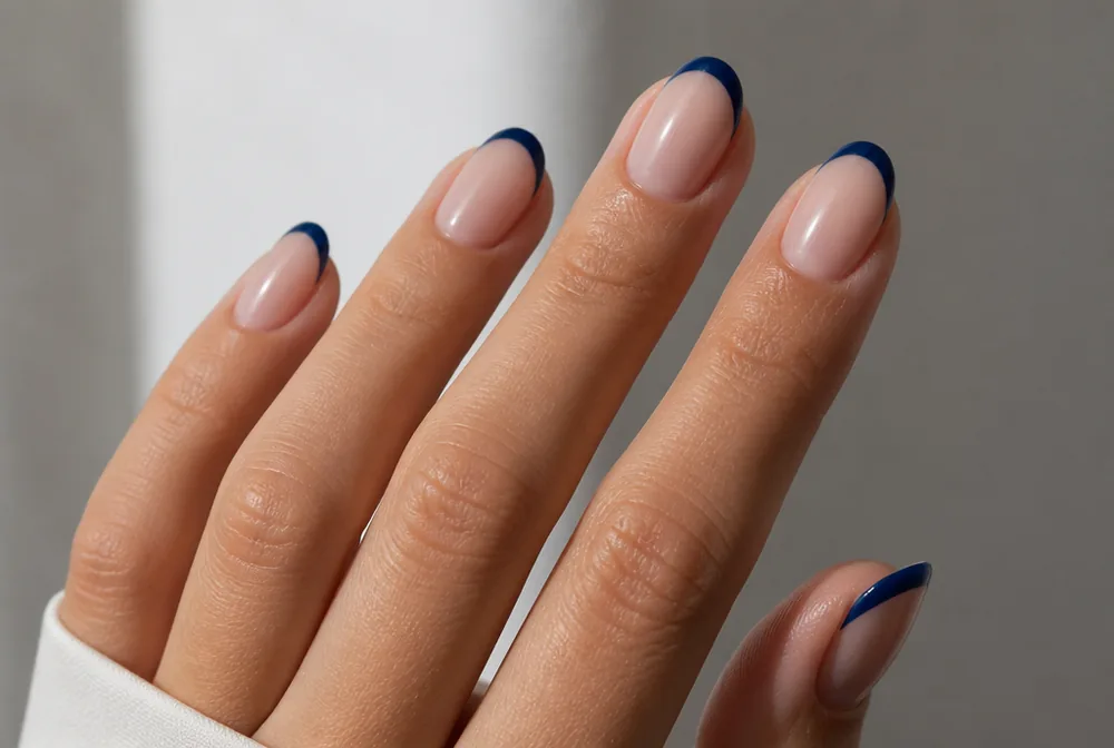 navy French tip nails on sheer nude base