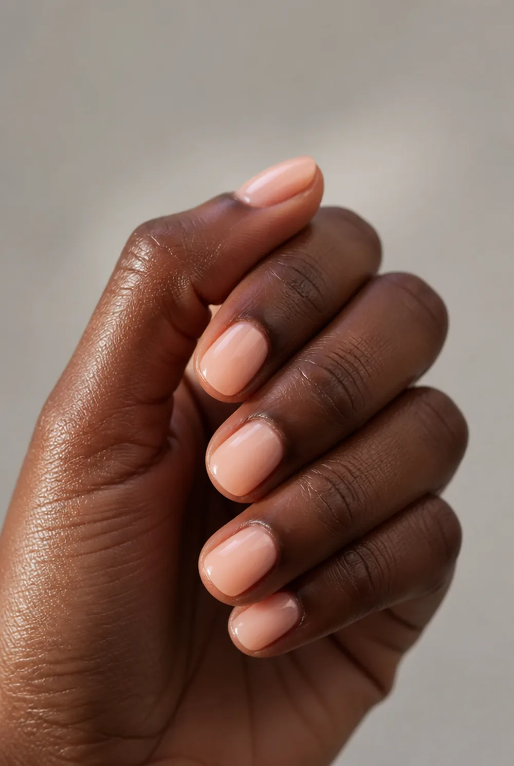 short peach squoval nail art on deep brown skin