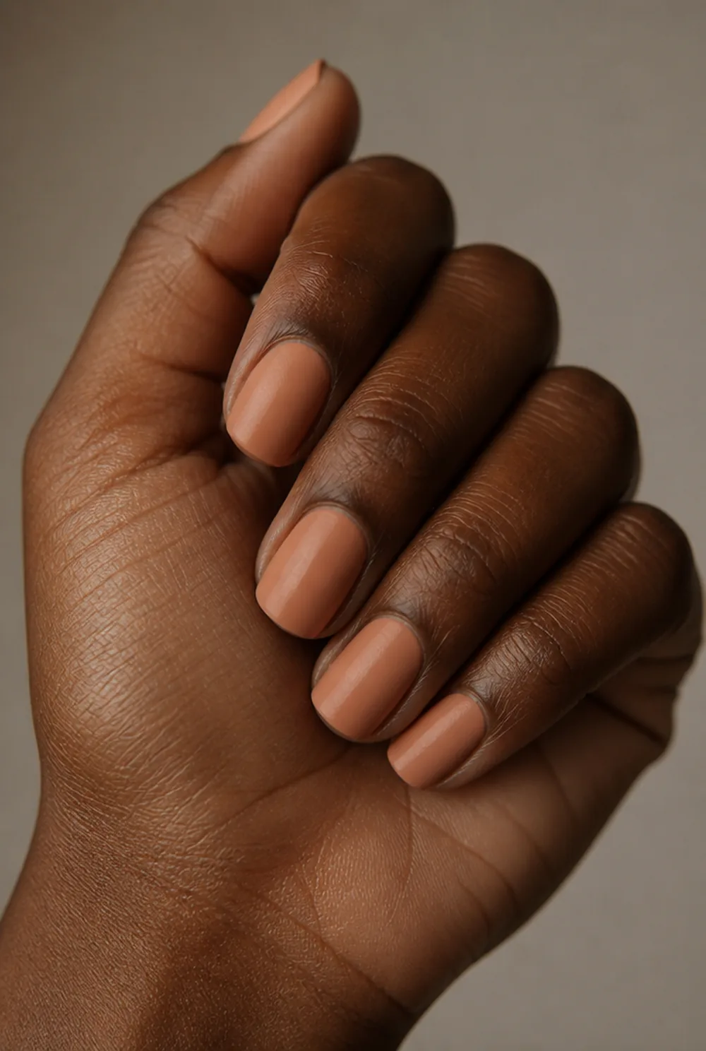 peach nude nail art on deep brown skin