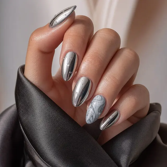 Silver chrome nails with a marble accent nail