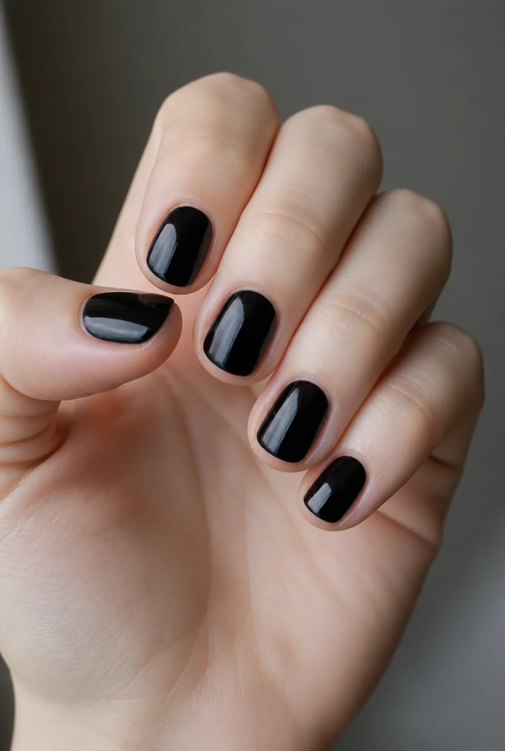 round black nail art on fair skin, short length
