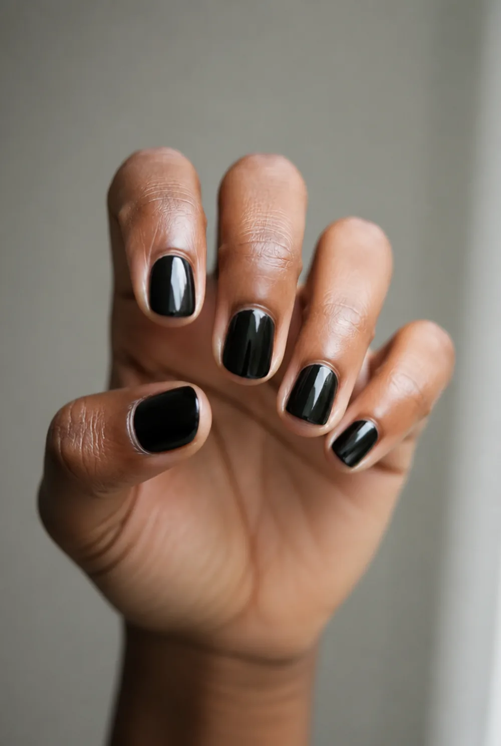 round black nail art on deep brown skin