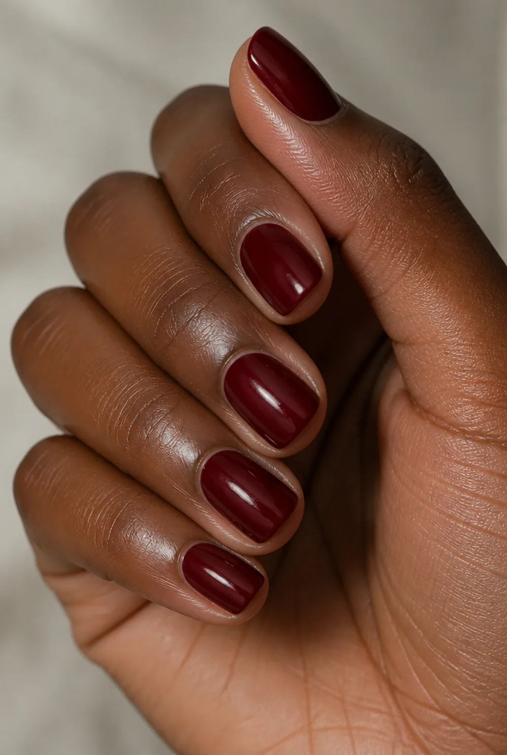 squoval burgundy nail art on deep brown skin