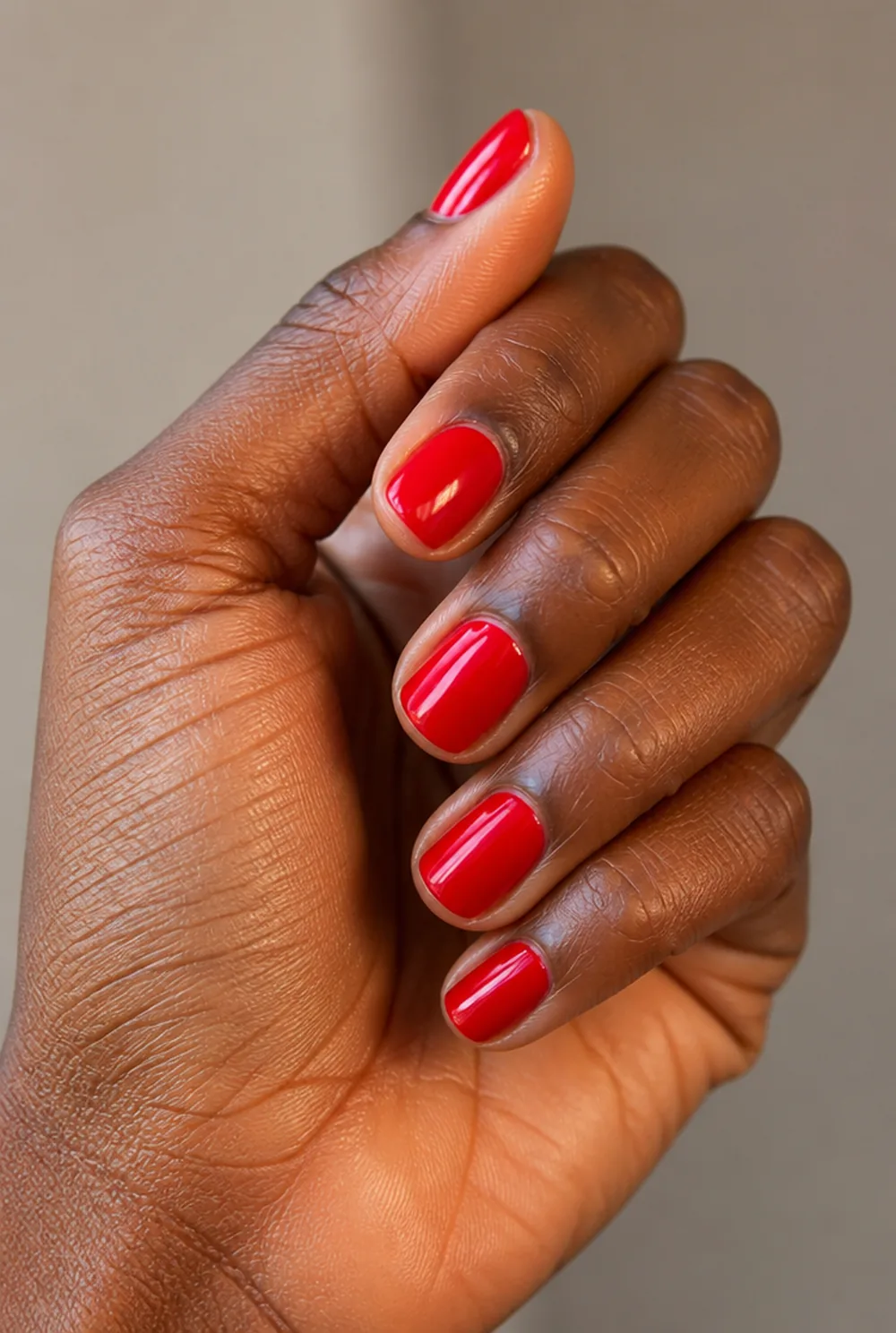 squoval red nail art on deep brown skin