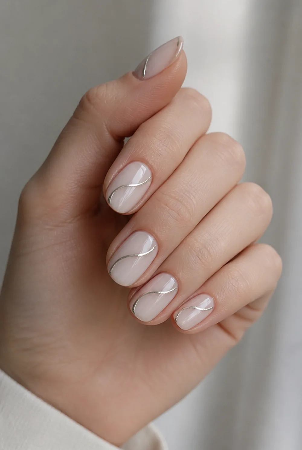 chrome swirl nail art on fair skin, short length